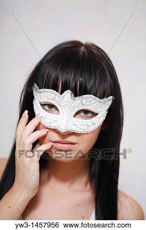 Stock Photograph - pretty brunette girl indoors weared in carnival mask. Fotosearch