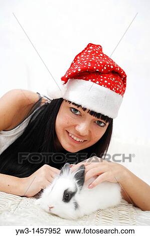 pretty brunette in Santa hat with white rabbit on the modern sofa View Large Photo Image Stock Image - pretty brunette in Santa hat with white rabbit on the modern sofa. Fotosearch