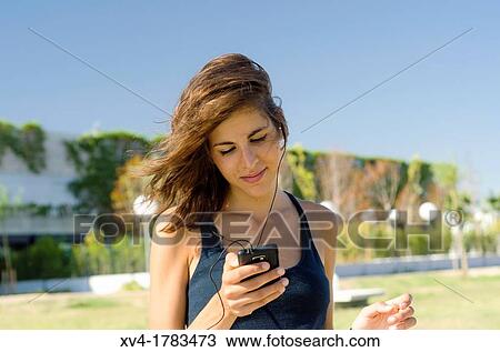 Pretty Brunette listening music on mobile at Ebro riverside at ExpoZaragoza outdoors area, Saragossa, Aragon, Spain View Large Photo Image Stock Image - Pretty Brunette listening music on mobile at Ebro riverside at ExpoZaragoza outdoors area, Saragossa, Aragon, Spain. Fotosearch