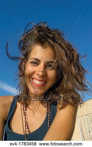 Stock Photo - Pretty Brunette seated at Ebro riverside at ExpoZaragoza outdoors area, Saragossa, Aragon, Spain. Fotosearch