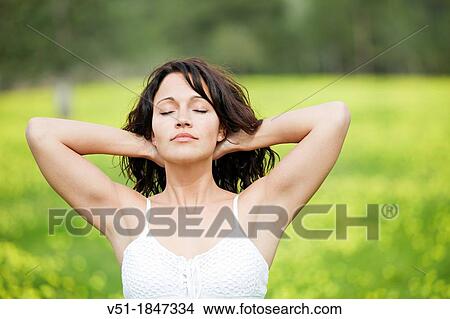 Picture - Pretty brunette woman breathing fresh air in countryside. Fotosearch