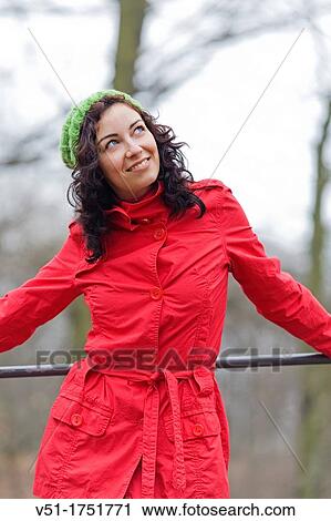 Stock Image - Pretty brunette woman in winter in a park. Fotosearch