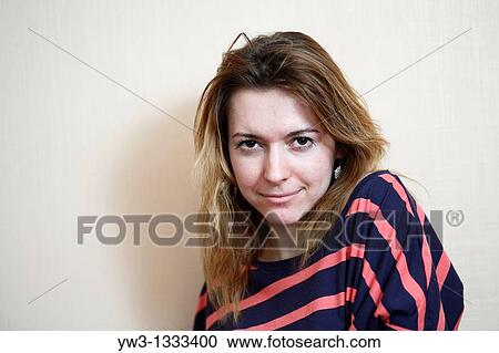 Stock Image - pretty girl against light wall blank expression. Fotosearch