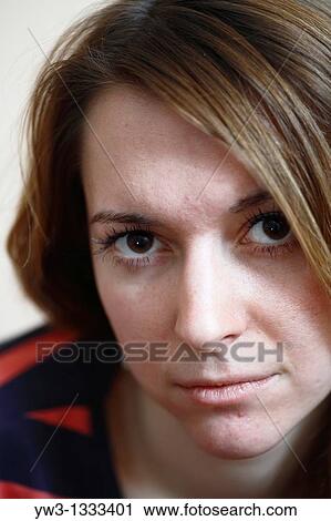 Stock Image - pretty girl against light wall blank expression. Fotosearch