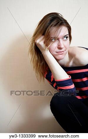 Stock Photo - pretty girl against light wall blank expression. Fotosearch