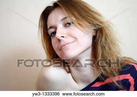 Stock Photograph - pretty girl against light wall blank expression. Fotosearch