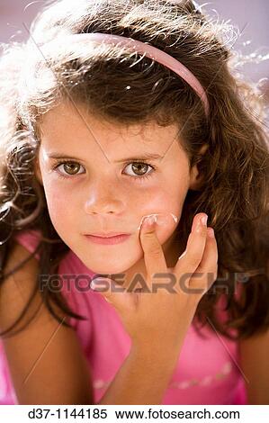 Stock Photography - Pretty girl applying facial cream. Fotosearch
