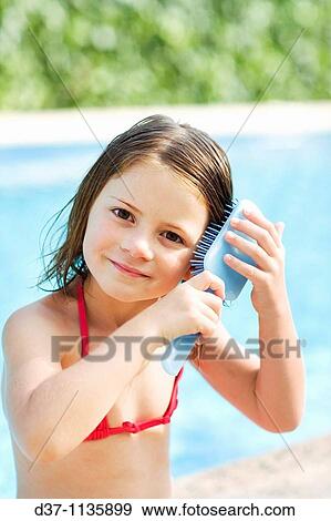 Pretty girl brushing her hair View Large Photo Image Stock Photo - Pretty girl brushing her hair. Fotosearch