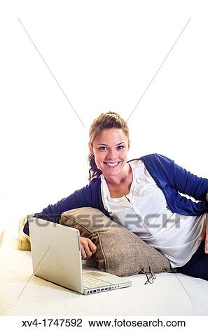 Stock Image - Pretty girl chatting on notebook in the bedroom. Fotosearch