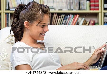 Pretty girl chatting on notebook in the bedroom View Large Photo Image Stock Image - Pretty girl chatting on notebook in the bedroom. Fotosearch