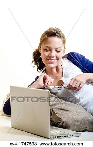 Pretty girl chatting on notebook in the bedroom View Large Photo Image Stock Photo - Pretty girl chatting on notebook in the bedroom. Fotosearch