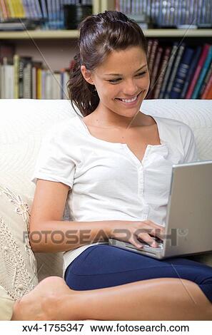 Pretty girl chatting on notebook in the bedroom View Large Photo Image Stock Photo - Pretty girl chatting on notebook in the bedroom. Fotosearch