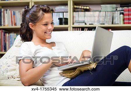 Pretty girl chatting on notebook in the bedroom View Large Photo Image Stock Photography - Pretty girl chatting on notebook in the bedroom. Fotosearch