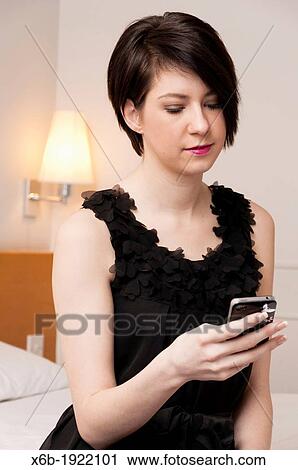 Pretty girl in little black dress texting on mobile phone View Large Photo Image Stock Image - Pretty girl in little black dress texting on mobile phone. Fotosearch