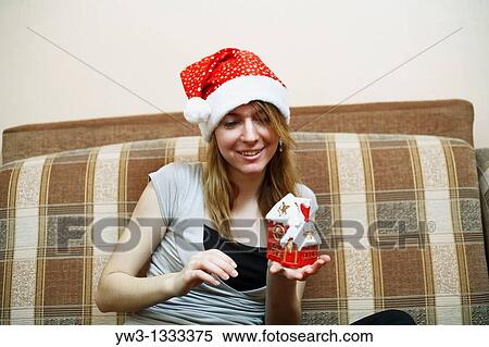 pretty girl in the Christmas hat on sofa with little red xmas house in hands View Large Photo Image Stock Photography - pretty girl in the Christmas hat on sofa with little red xmas house in hands. Fotosearch
