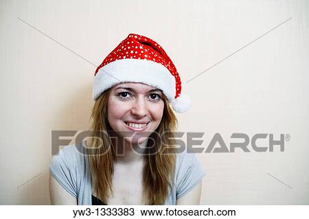 pretty girl in the Christmas hat against light wall smiling View Large Photo Image Stock Image - pretty girl in the Christmas hat against light wall smiling. Fotosearch