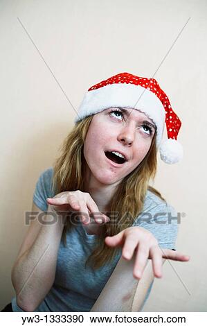 pretty girl in the Christmas hat grimasing View Large Photo Image Stock Image - pretty girl in the Christmas hat grimasing. Fotosearch
