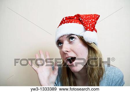 pretty girl in the Christmas hat grimasing View Large Photo Image Stock Photo - pretty girl in the Christmas hat grimasing. Fotosearch