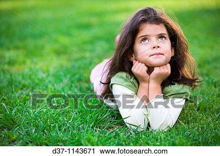 Pretty girl laying on the grass thinking View Large Photo Image Stock Image - Pretty girl laying on the grass thinking. Fotosearch