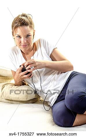 Stock Photo - Pretty girl listening music in the bedroom. Fotosearch
