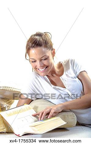 Picture - Pretty girl reading book in the bedroom. Fotosearch