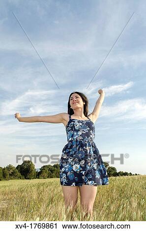 Stock Image - Pretty girl relaxing and enjoy in the wheat field. Fotosearch