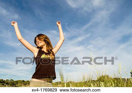Stock Photo - Pretty girl relaxing and enjoy in the wheat field. Fotosearch