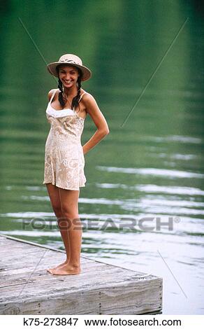 Pretty girl standing on a dock View Large Photo Image Stock Photo - Pretty girl standing on a dock. Fotosearch