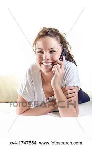 Pretty girl talk with mobile phone in the bedroom View Large Photo Image Picture - Pretty girl talk with mobile phone in the bedroom. Fotosearch