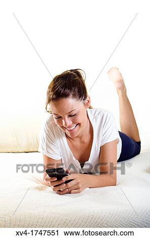 Pretty girl talk with mobile phone in the bedroom View Large Photo Image Stock Image - Pretty girl talk with mobile phone in the bedroom. Fotosearch
