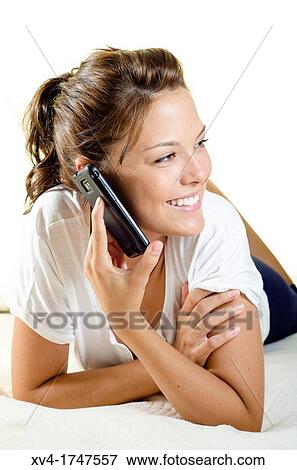 Pretty girl talk with mobile phone in the bedroom View Large Photo Image Stock Photo - Pretty girl talk with mobile phone in the bedroom. Fotosearch