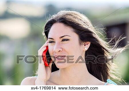 Pretty girl talks with mobile phone in the countryside View Large Photo Image Picture - Pretty girl talks with mobile phone in the countryside. Fotosearch