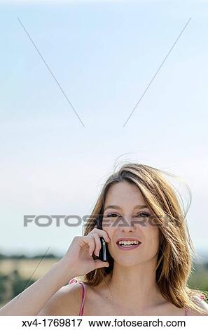Pretty girl talks with mobile phone in the countryside View Large Photo Image Stock Photo - Pretty girl talks with mobile phone in the countryside. Fotosearch