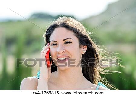 Pretty girl talks with mobile phone in the countryside View Large Photo Image Stock Photography - Pretty girl talks with mobile phone in the countryside. Fotosearch