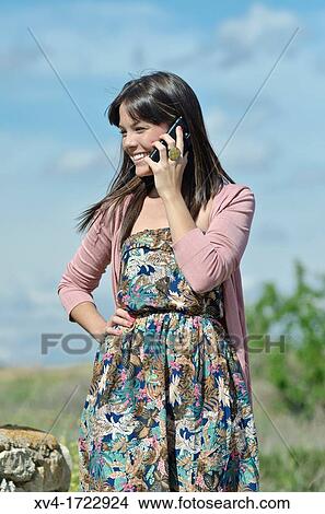 Picture - Pretty girl with cell phone in outdoors. Fotosearch