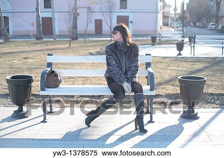 Stock Photography - pretty model wearing fur coat in the winter on park bench. Fotosearch