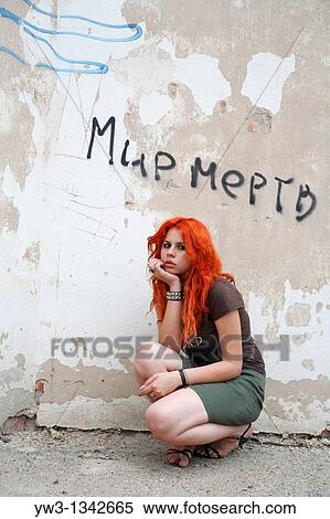 pretty redhead girl against obsolete wall with words in Russian? World is dead? View Large Photo Image Stock Photography - pretty redhead girl against obsolete wall with words in Russian? World is dead?. Fotosearch