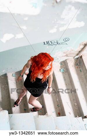Stock Image - pretty redhead girl on the stairway. Fotosearch