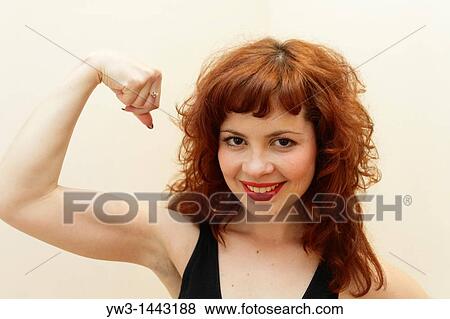 Stock Photo - Pretty redhead young woman do fitness indoors. Fotosearch
