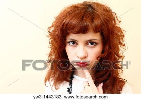 Stock Image - Pretty redhead young woman portrait indoors. Fotosearch