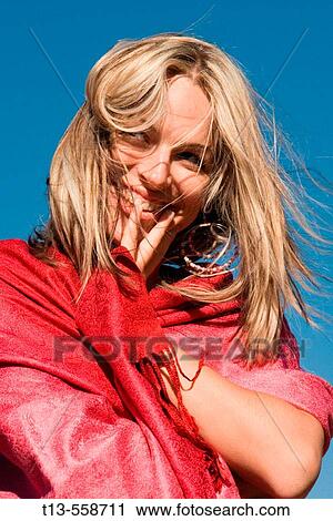 Pretty smiling girl dressed in red, isolated on blue sky background View Large Photo Image Stock Image - Pretty smiling girl dressed in red, isolated on blue sky background. Fotosearch