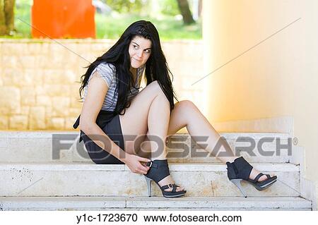 Stock Image - Pretty teen girl on stairs, expecting someone. Fotosearch
