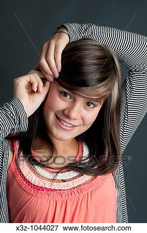 Pretty thirteen year old girl putting up her hair with a hair grip View Large Photo Image Stock Photo - Pretty thirteen year old girl putting up her hair with a hair grip. Fotosearch