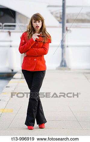 Stock Photo - Pretty woman standing dressed in Red. Fotosearch