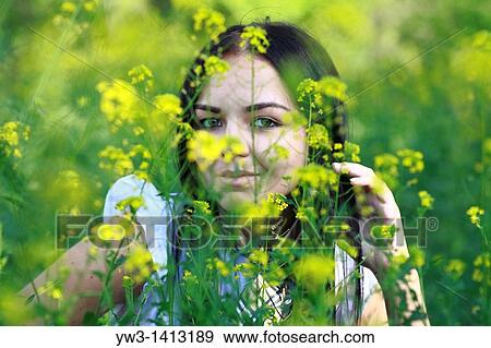 Pretty young 20-25 years woman in the garden among grass flowers View Large Photo Image Stock Photo - Pretty young 20-25 years woman in the garden among grass flowers. Fotosearch