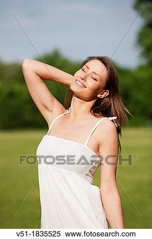 Stock Photography - Pretty young woman enjoying in park. Fotosearch