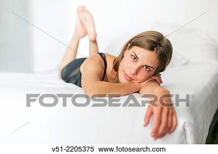 Pretty young woman in bed looking at camera View Large Photo Image Stock Photography - Pretty young woman in bed looking at camera. Fotosearch