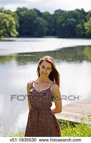 Stock Image - Pretty young woman in lake smiling at camera. Fotosearch