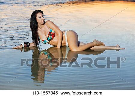 Pretty young woman in lying in very shallow water View Large Photo Image Stock Photography - Pretty young woman in lying in very shallow water. Fotosearch