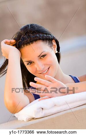 Stock Photograph - Pretty young woman is checking her nails. Fotosearch